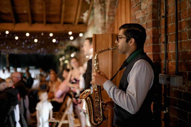 Alex performing the saxophone at a venue