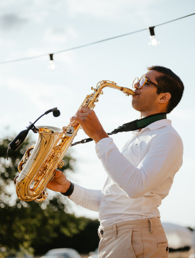 Alex playing the saxophone at an outside event